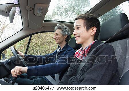 Stock Photo - Mature man and teenage son driving car. Fotosearch