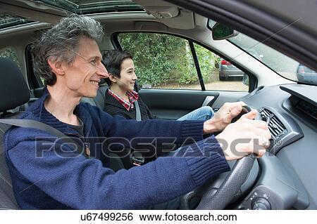 Mature man driving car with teenage son View Large Photo Image Stock Photograph - Mature man driving car with teenage son. Fotosearch