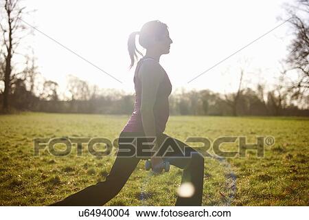 Mature woman training with dumbbells in field View Large Photo Image Picture - Mature woman training with dumbbells in field. Fotosearch