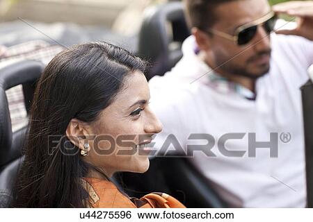 Stock Photograph - Mid adult couple in convertible car. Fotosearch