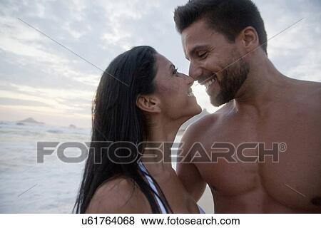 "Mid adult couple standing on beach, face to face, touching noses" View Large Photo Image Stock Photo - "Mid adult couple standing on beach, face to face, touching noses". Fotosearch