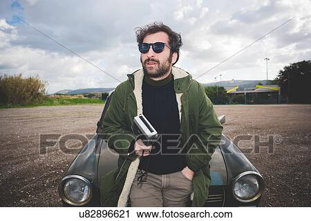 Mid adult man leaning against vintage car with vintage movie camera View Large Photo Image Stock Image - Mid adult man leaning against vintage car with vintage movie camera. Fotosearch