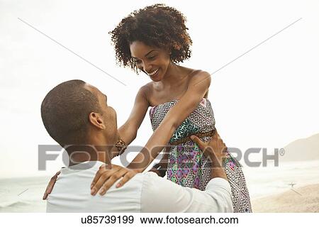 "Mid adult man lifting up girlfriend on beach, Rio De Janeiro, Brazil" View Large Photo Image Stock Photo - "Mid adult man lifting up girlfriend on beach, Rio De Janeiro, Brazil". Fotosearch