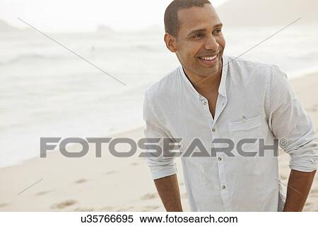 Stock Photography - "Mid adult man on misty beach, Rio De Janeiro, Brazil". Fotosearch