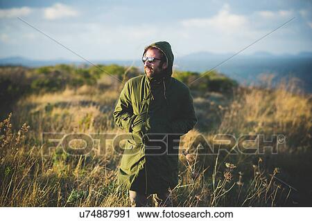 Stock Image - "Mid adult man strolling along coast, Sorso, Sassari, Sardinia, Italy". Fotosearch