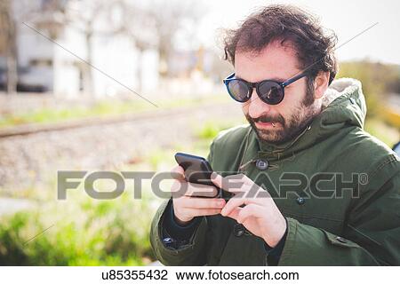 Mid adult man texting on smartphone View Large Photo Image Stock Image - Mid adult man texting on smartphone. Fotosearch