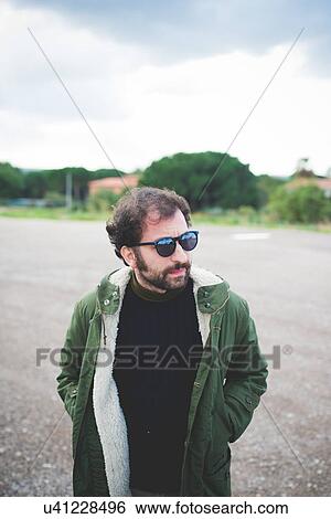 Mid adult man wearing sunglasses looking sideways on waste ground View Large Photo Image Stock Photograph - Mid adult man wearing sunglasses looking sideways on waste ground. Fotosearch