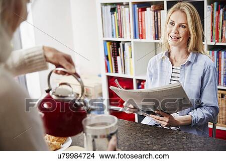 Mid adult woman reading newspaper View Large Photo Image Picture - Mid adult woman reading newspaper. Fotosearch