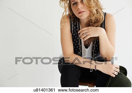 Stock Image - Mid adult woman sitting resting elbow on knee. Fotosearch