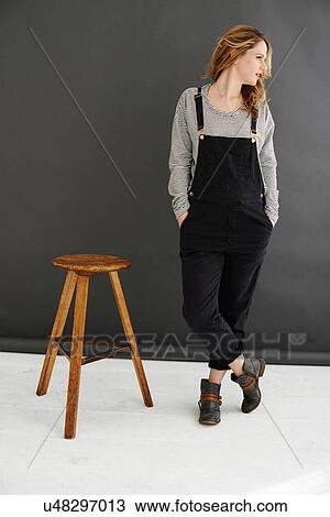 "Mid adult woman standing next to stool, looking away" View Large Photo Image Stock Image - "Mid adult woman standing next to stool, looking away". Fotosearch