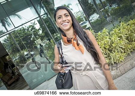 "Mid adult woman standing outside building, smiling" View Large Photo Image Stock Photograph - "Mid adult woman standing outside building, smiling". Fotosearch