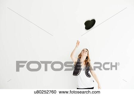 "Mid adult woman throwing hat in the air, copy space" View Large Photo Image Stock Image - "Mid adult woman throwing hat in the air, copy space". Fotosearch