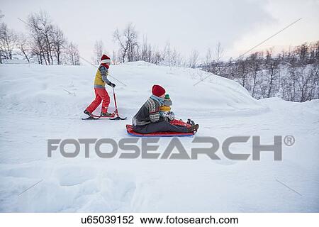 "Mother and two sons on toboggan and snow scooter on snow covered hill, Hemavan, Sweden" View Large Photo Image Stock Image - "Mother and two sons on toboggan and snow scooter on snow covered hill, Hemavan, Sweden". Fotosearch