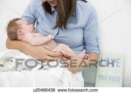 Stock Photo - Mother cradling baby in arms. Fotosearch