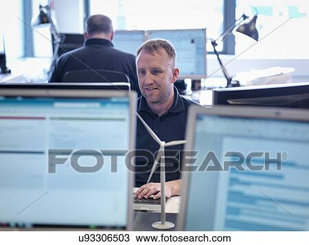 Offshore windfarm engineer working with computer screens in office View Large Photo Image Stock Image - Offshore windfarm engineer working with computer screens in office. Fotosearch