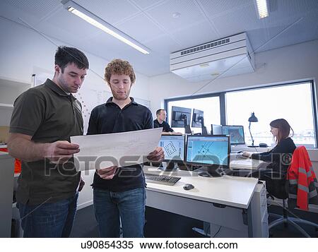 Offshore windfarm engineers discussing plans in office View Large Photo Image Stock Photography - Offshore windfarm engineers discussing plans in office. Fotosearch
