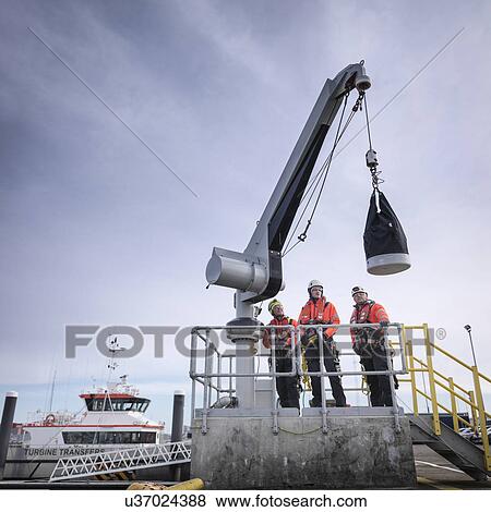 Offshore windfarm engineers in port with crane View Large Photo Image Stock Photo - Offshore windfarm engineers in port with crane. Fotosearch