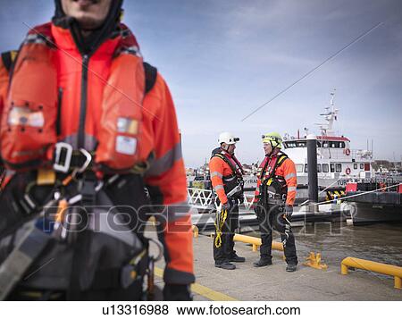 Offshore windfarm engineers on quayside with boats in the background View Large Photo Image Stock Photo - Offshore windfarm engineers on quayside with boats in the background. Fotosearch