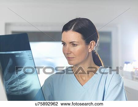 Orthopaedic consultant viewing x-ray of hand View Large Photo Image Stock Image - Orthopaedic consultant viewing x-ray of hand. Fotosearch
