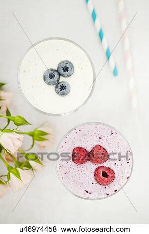 Overhead still life of fresh raspberry and blueberry smoothies View Large Photo Image Stock Photo - Overhead still life of fresh raspberry and blueberry smoothies. Fotosearch
