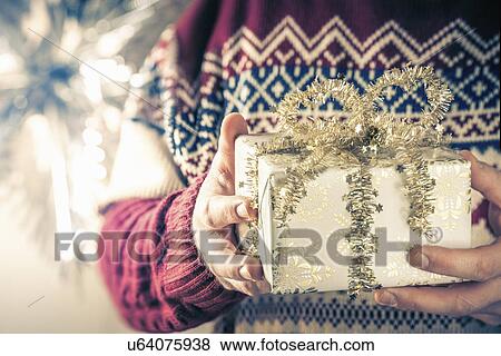 Stock Photo - Person holding christmas gift. Fotosearch