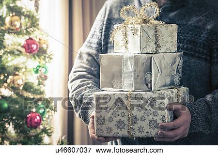 Person holding stack of christmas gifts View Large Photo Image Stock Photo - Person holding stack of christmas gifts. Fotosearch