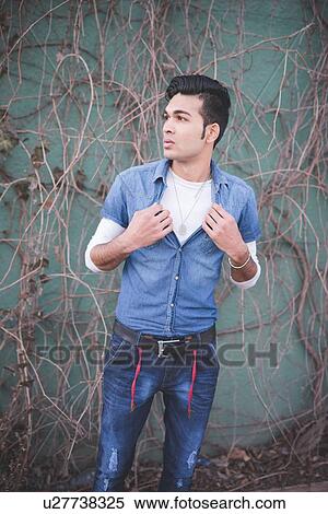 Portrait of a young man holding shirt View Large Photo Image Stock Photography - Portrait of a young man holding shirt. Fotosearch