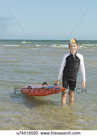 "Portrait of boy nipper (child surf life savers) holding up surfboard, Altona, Melbourne, Australia" View Large Photo Image Stock Image - "Portrait of boy nipper (child surf life savers) holding up surfboard, Altona, Melbourne, Australia". Fotosearch