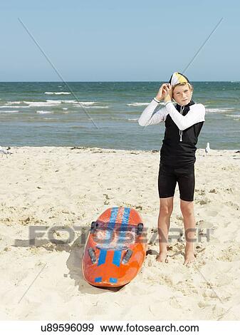 "Portrait of boy nipper (child surf life savers) putting on cap, Altona, Melbourne, Australia" View Large Photo Image Stock Photo - "Portrait of boy nipper (child surf life savers) putting on cap, Altona, Melbourne, Australia". Fotosearch