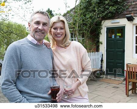 Portrait of couple drinking in front of pub View Large Photo Image Stock Photo - Portrait of couple drinking in front of pub. Fotosearch