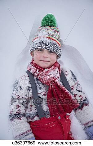 Portrait of cute boy lying in deep snow View Large Photo Image Stock Photo - Portrait of cute boy lying in deep snow. Fotosearch