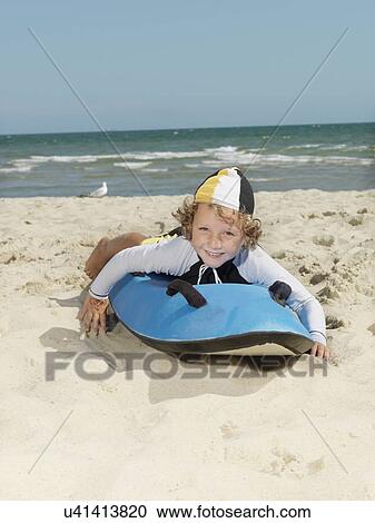 "Portrait of cute boy nipper (child surf life savers) lying on surfboard at beach, Altona, Melbourne, Australia" View Large Photo Image Stock Image - "Portrait of cute boy nipper (child surf life savers) lying on surfboard at beach, Altona, Melbourne, Australia". Fotosearch