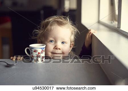 Portrait of female toddler peering from kitchen breakfast bar View Large Photo Image Stock Photo - Portrait of female toddler peering from kitchen breakfast bar. Fotosearch