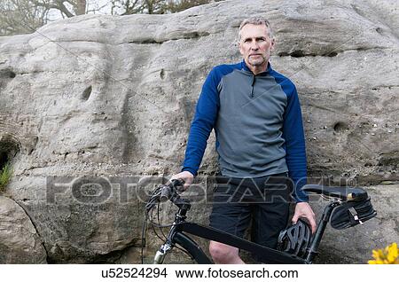 Portrait of male mountain biker on rock formation View Large Photo Image Picture - Portrait of male mountain biker on rock formation. Fotosearch