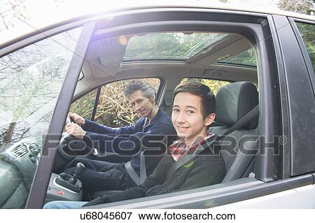 Stock Photo - Portrait of mature man and teenage son driving a car. Fotosearch