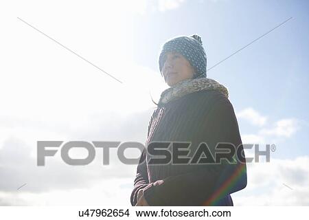 Portrait of mature woman wearing knit hat against blue sky View Large Photo Image Picture - Portrait of mature woman wearing knit hat against blue sky. Fotosearch