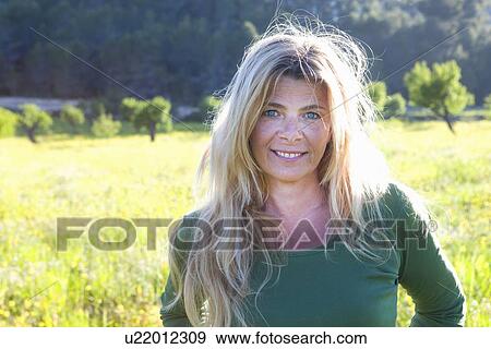 Portrait of mature woman with long blond hair in field View Large Photo Image Stock Photo - Portrait of mature woman with long blond hair in field. Fotosearch
