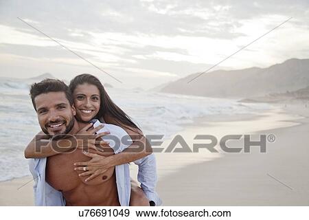 "Portrait of mid adult couple on beach, man carrying woman on back" View Large Photo Image Stock Photo - "Portrait of mid adult couple on beach, man carrying woman on back". Fotosearch