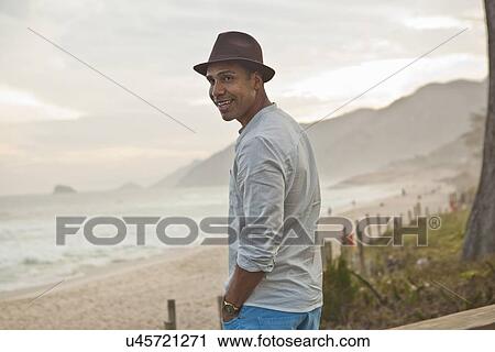 Stock Image - "Portrait of mid adult man at beach, Rio De Janeiro, Brazil". Fotosearch