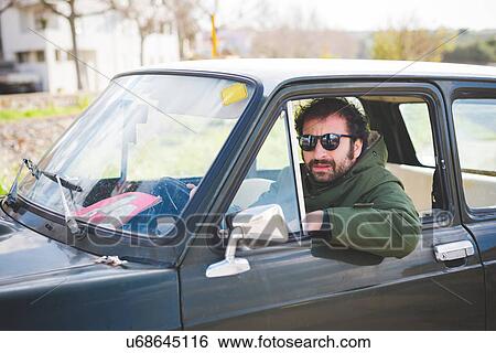 Portrait of mid adult man driving vintage car View Large Photo Image Stock Photograph - Portrait of mid adult man driving vintage car. Fotosearch