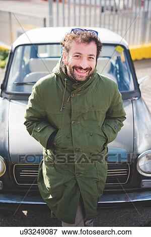 Portrait of mid adult man leaning on vintage car View Large Photo Image Stock Photo - Portrait of mid adult man leaning on vintage car. Fotosearch