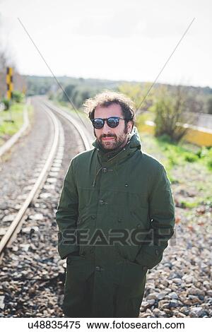 Portrait of mid adult man wearing sunglasses next to railway track View Large Photo Image Stock Photography - Portrait of mid adult man wearing sunglasses next to railway track. Fotosearch