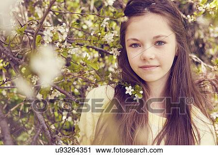 Stock Image - Portrait of pretty girl and tree blossom. Fotosearch