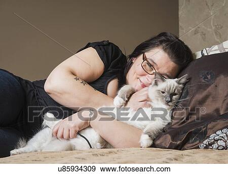 "Portrait of Ragdoll cat with owner, relaxing on bed" View Large Photo Image Stock Photo - "Portrait of Ragdoll cat with owner, relaxing on bed". Fotosearch