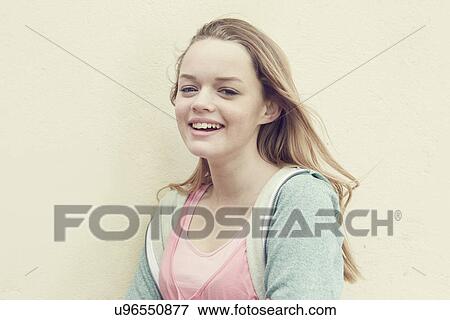 Portrait of smiling girl with long blond hair in front of wall View Large Photo Image Stock Photo - Portrait of smiling girl with long blond hair in front of wall. Fotosearch