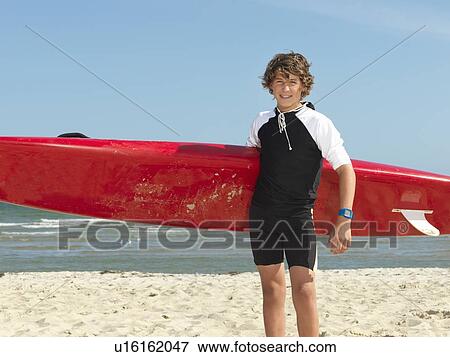 Stock Photo - "Portrait of teenage boy nipper (child surf life savers) with surfboard, Altona, Melbourne, Australia". Fotosearch