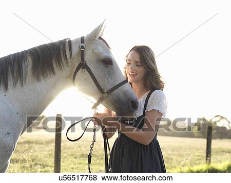 Portrait of teenage girl and her grey horse in sunlit field View Large Photo Image Stock Photo - Portrait of teenage girl and her grey horse in sunlit field. Fotosearch