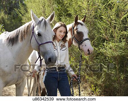 Portrait of teenage girl leading two horses View Large Photo Image Stock Photo - Portrait of teenage girl leading two horses. Fotosearch