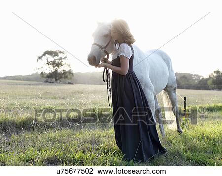 Portrait of teenage girl with grey horse in sunlit field View Large Photo Image Stock Image - Portrait of teenage girl with grey horse in sunlit field. Fotosearch