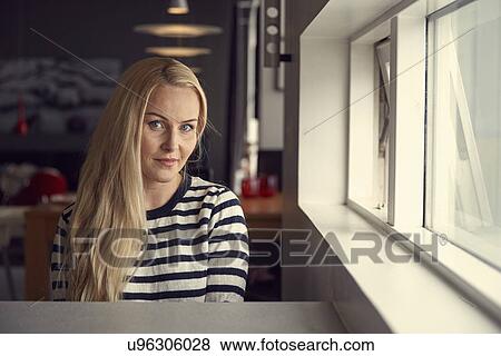 Portrait of woman with long blond hair sitting at kitchen breakfast bar View Large Photo Image Stock Photo - Portrait of woman with long blond hair sitting at kitchen breakfast bar. Fotosearch